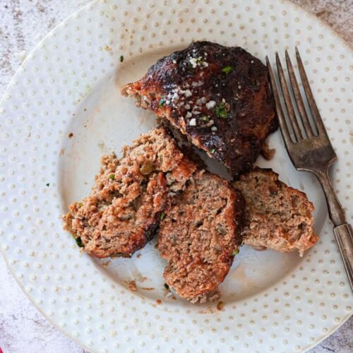 Finished air fryer meatloaf sliced on a plate.