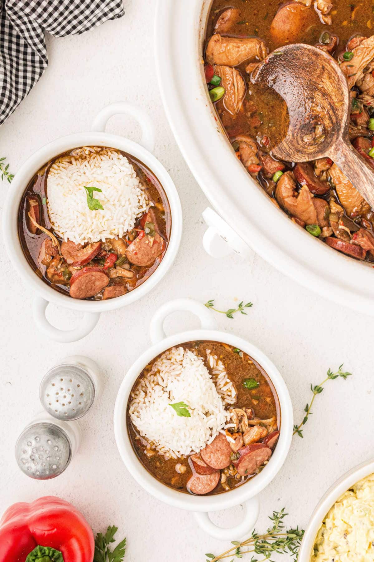 Two bowls of finished gumbo with rice in them.
