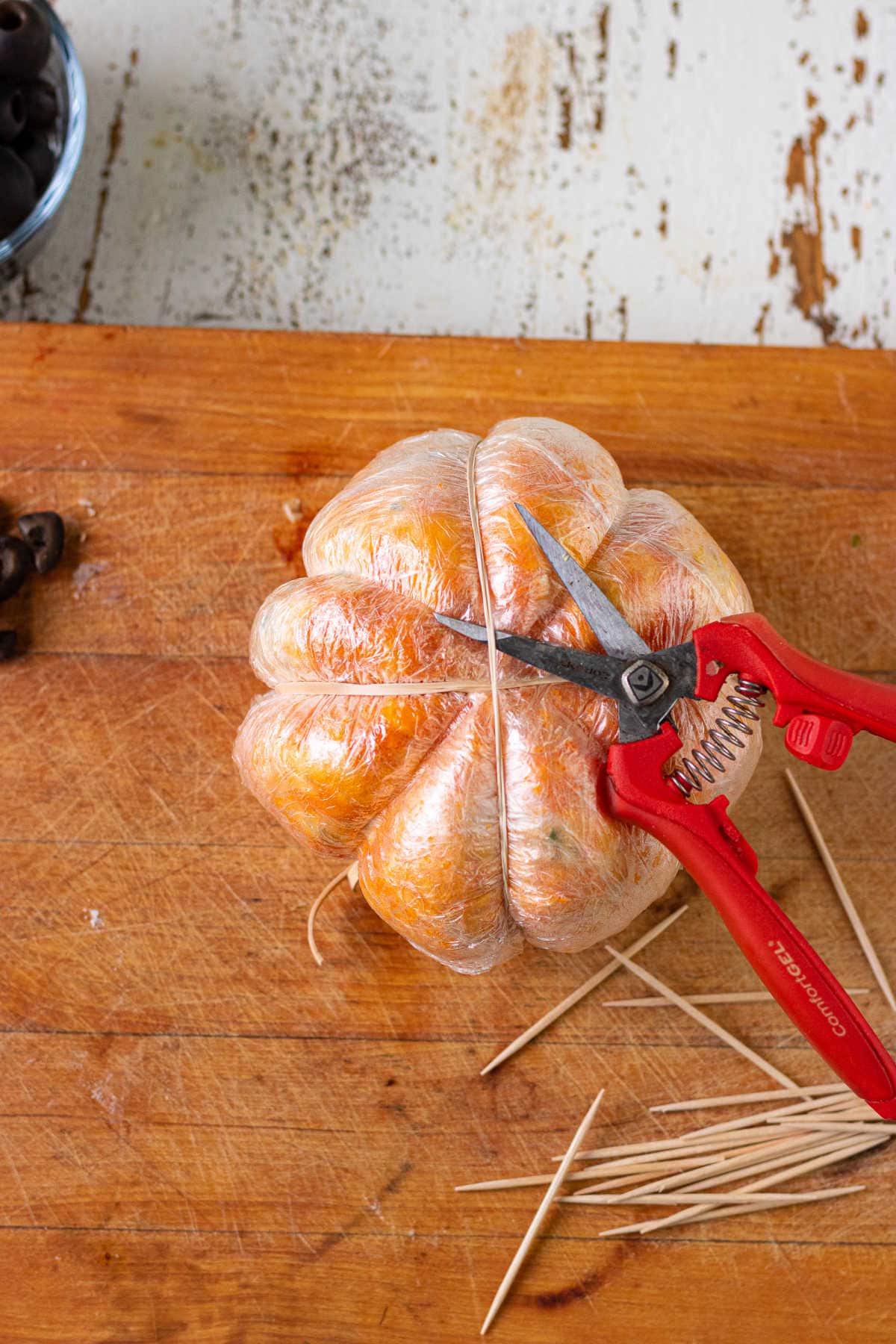 Cutting the rubber bands of the cheeseball.