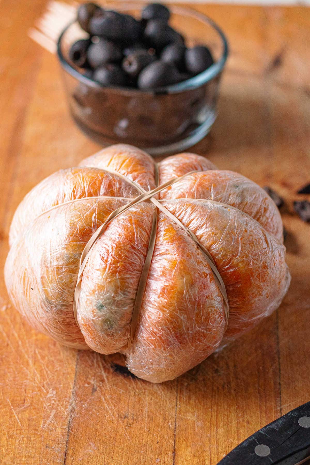 Cheeseball wrapped in plastic with rubberbands.