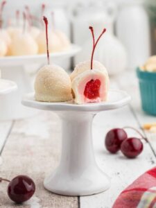 White chocolate covered cherries on a white cakeplate.