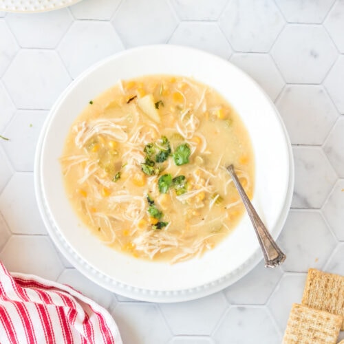 Crockpot chicken corn chowder with a spoon in it.