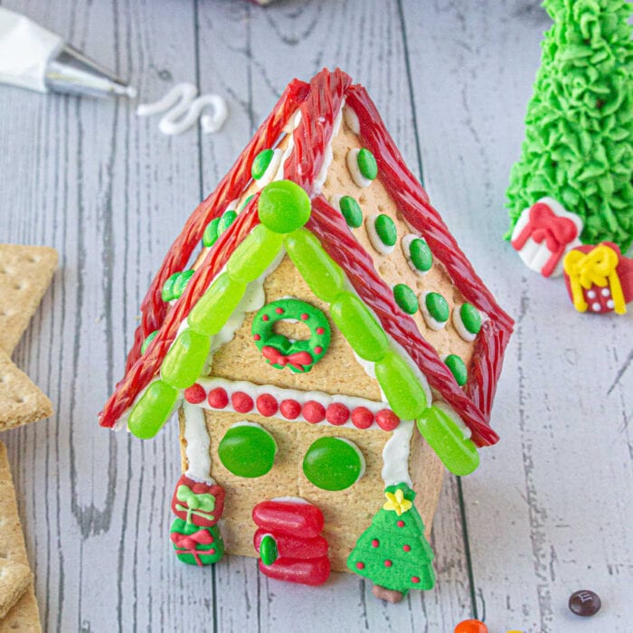 A finished graham cracker gingerbread house on a table.