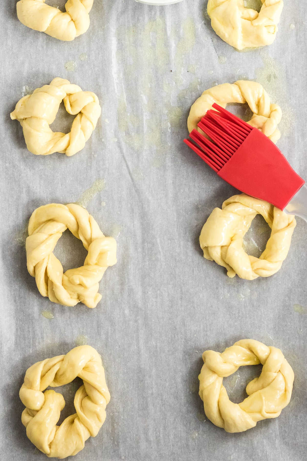 Circles of dough being brushed with butter.