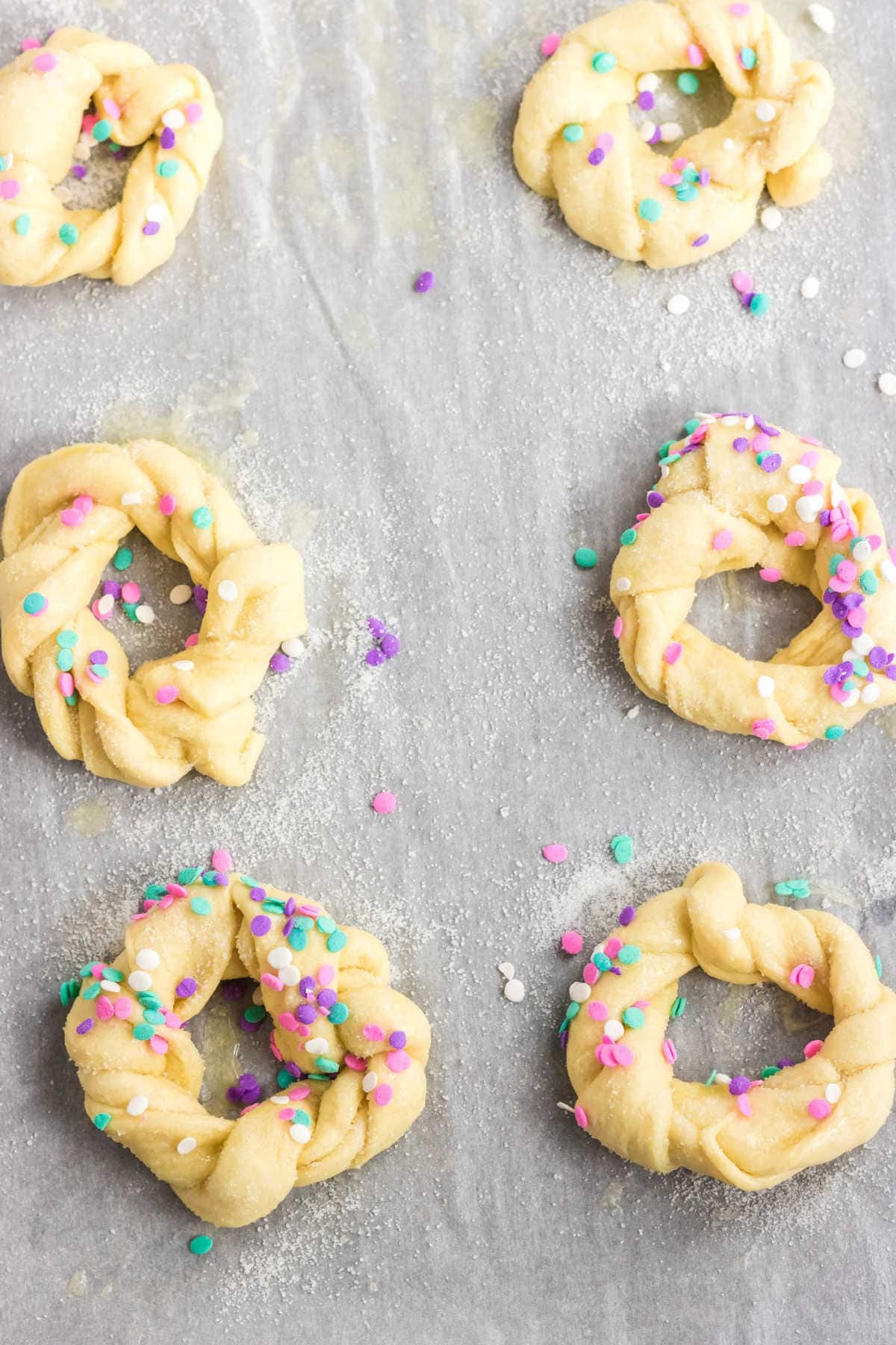 Unbaked rolls covered in sprinkles.