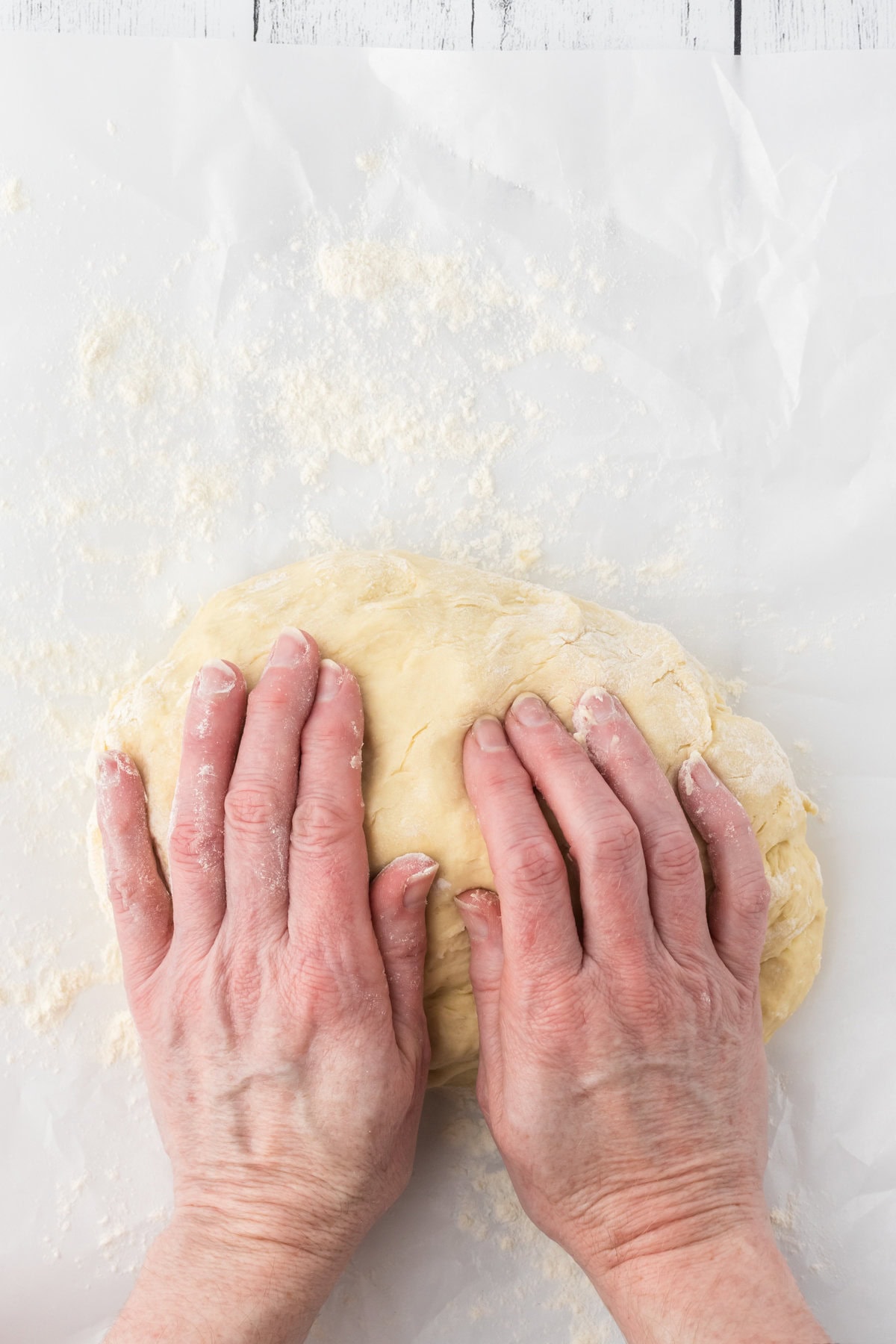 Dough being kneaded on a table.