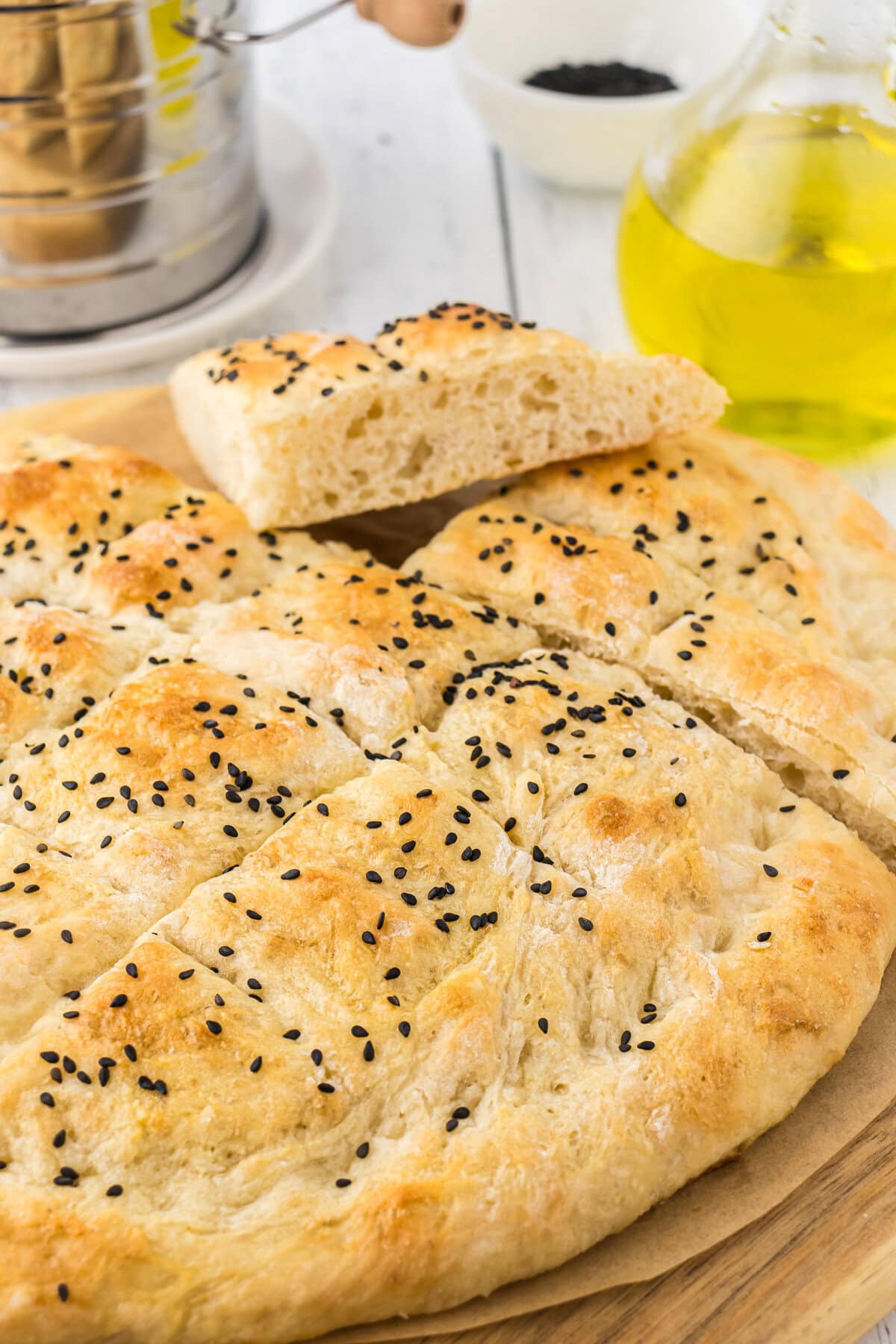 A golden brown loaf of Turkish bread with black sesame seeds on top.