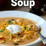 Closeup of enchilada soup in a bowl with a text overlay for Pinterest.