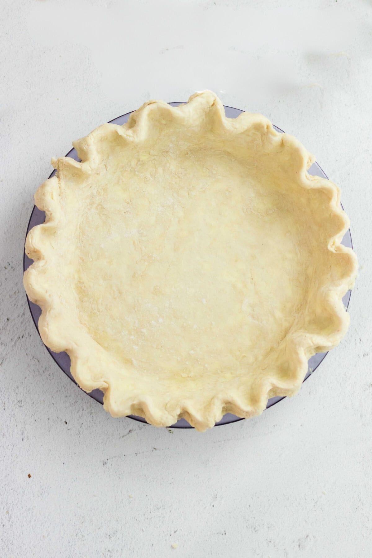 Unbaked pie crust in a glass pie plate.