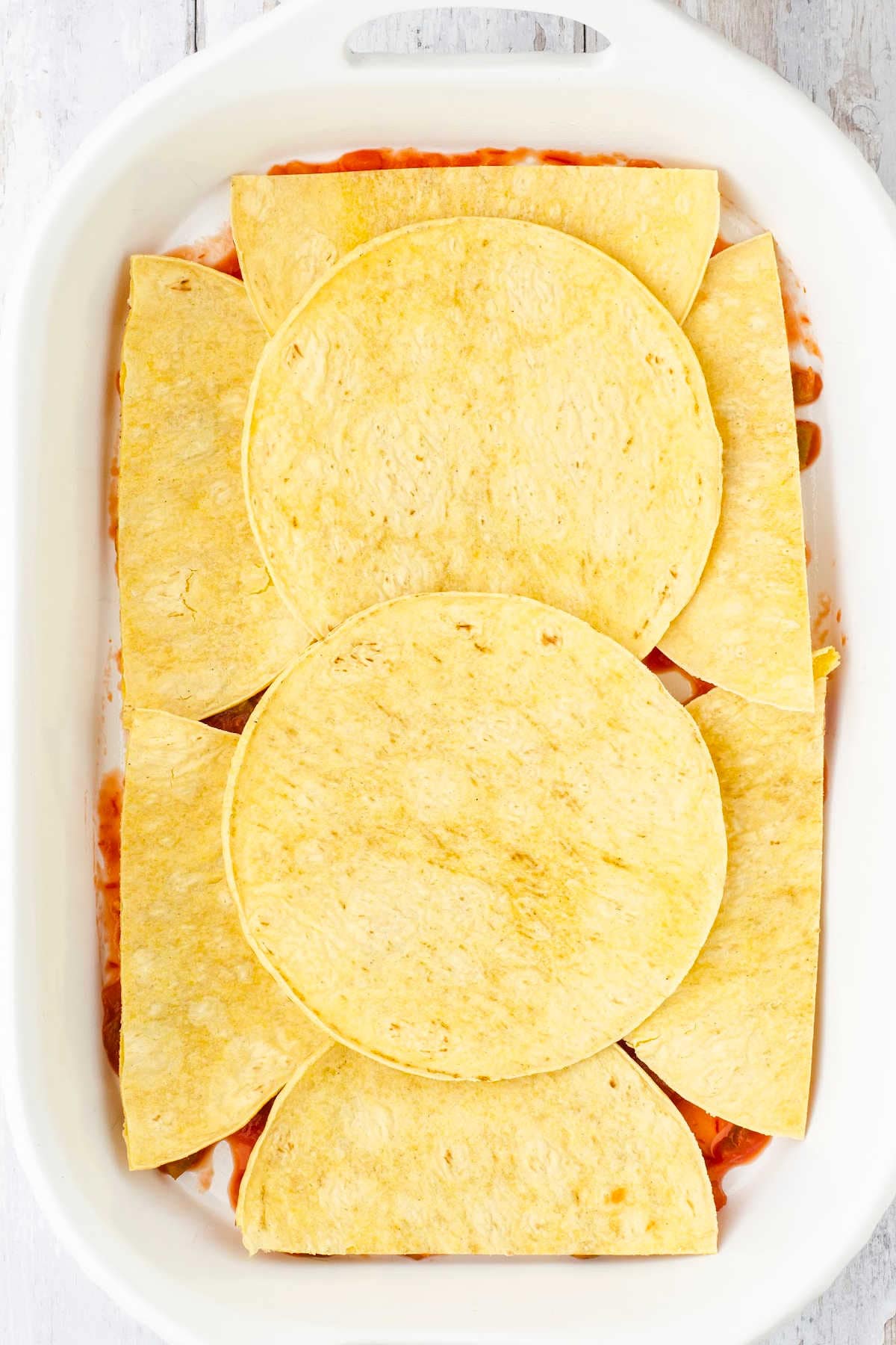 A layer of corn tortillas in a baking dish.