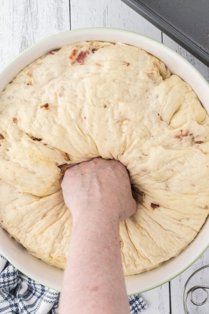 A fist punching down risen dough.