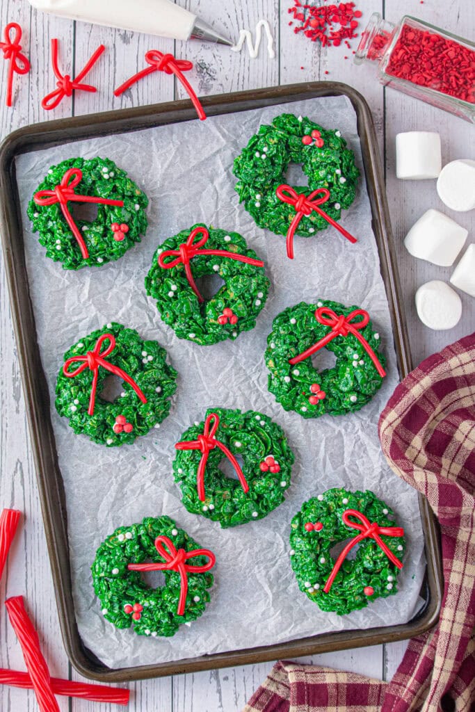 Overhead view of cornflake wreath cookies on a baking sheet.