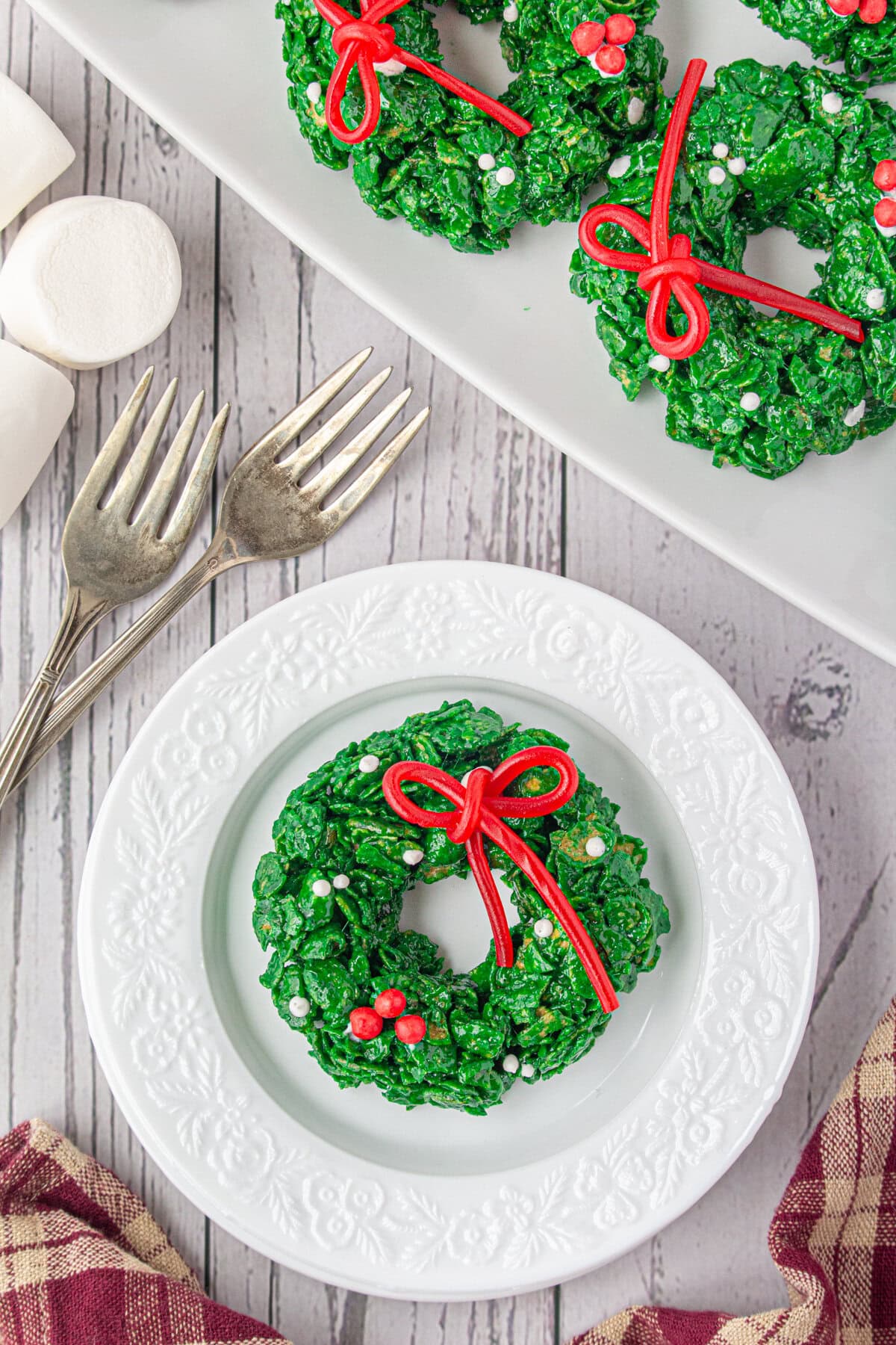 Cornflake Christmas wreath cookies on a plate and a platter.