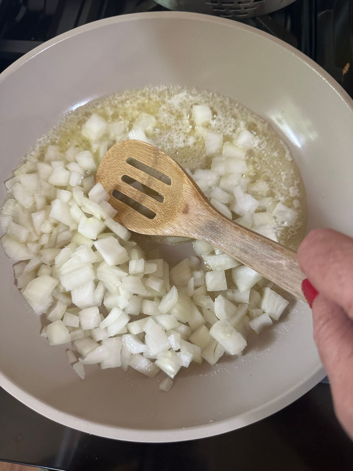 Sautéing the onions and garlic in a skillet.