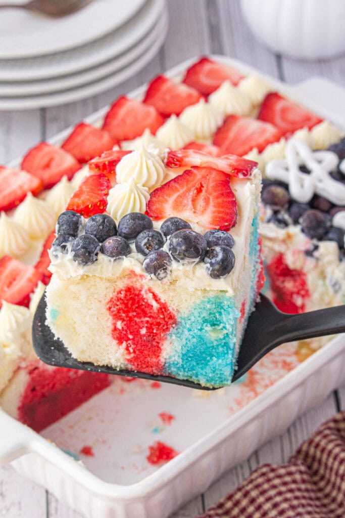 A piece of red, white, and blue cake being served.