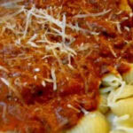 A closeup of shell pasta with ground beef and cream y vodka sauce with a title text overlay for Pinterest.