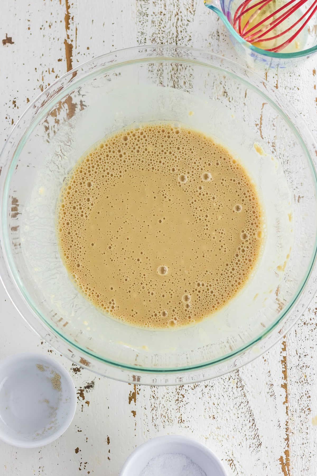 Bubbly yeast and water mixture in a glass bowl.