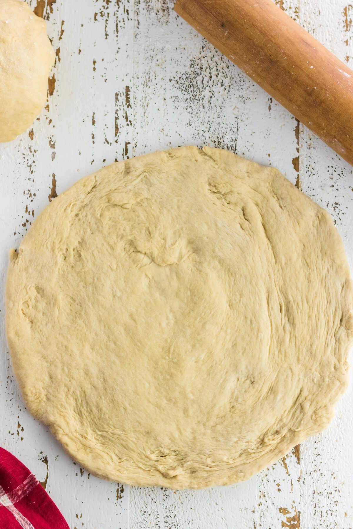 Dough has been rolled into a pizza crust.