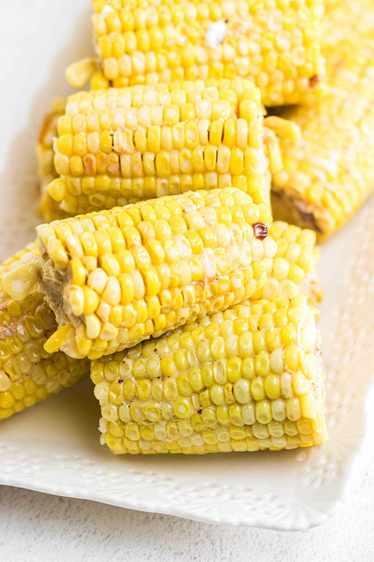 Closeup of cooked corn covered in melted butter.
