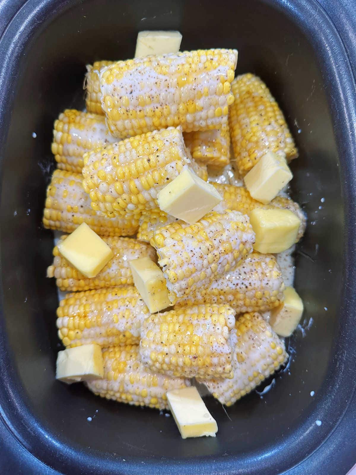 Corn in the slow cooker with butter on top.