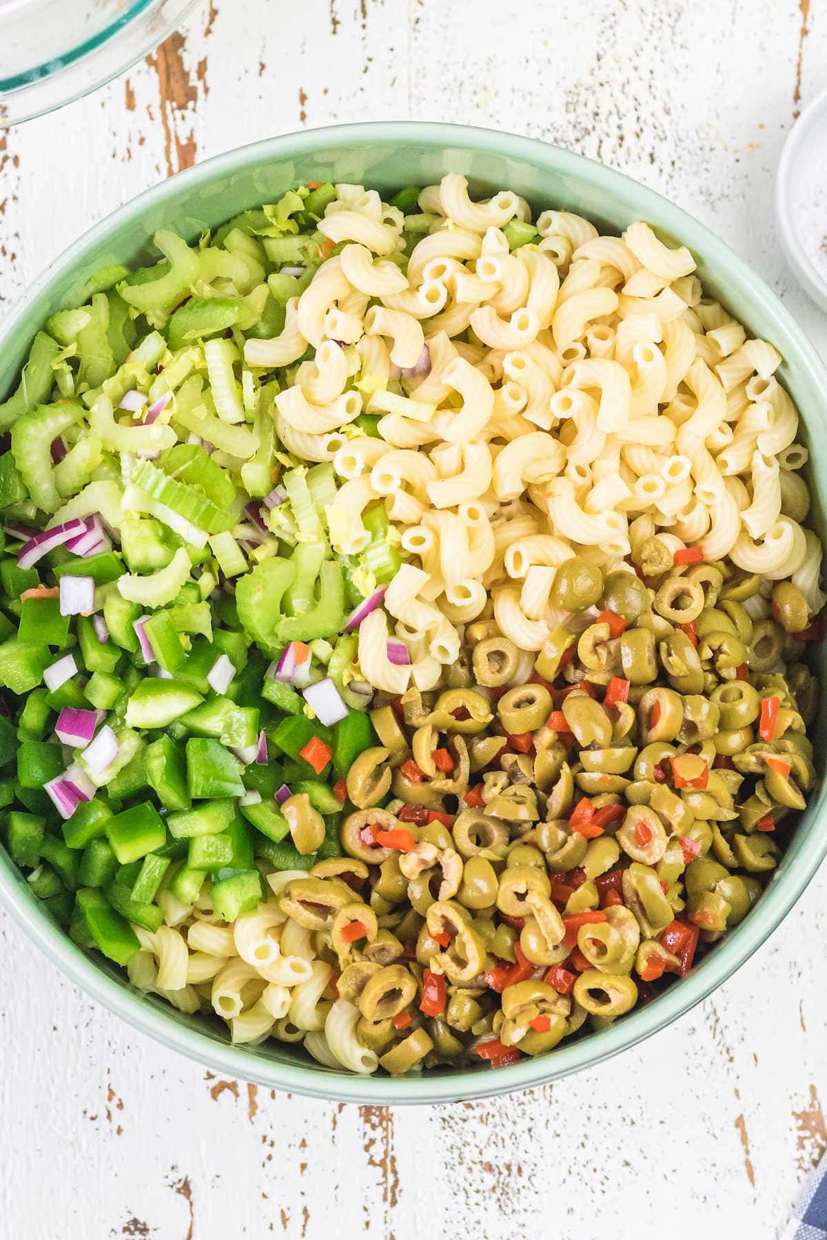 Macaroni, celery, and other salad ingredients in a bowl.