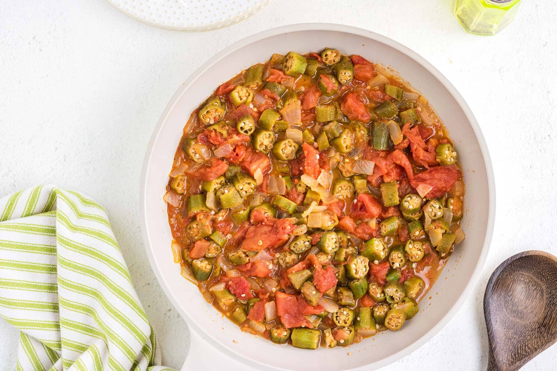 An overhead view of a big serving bowl of okra and tomatoes.