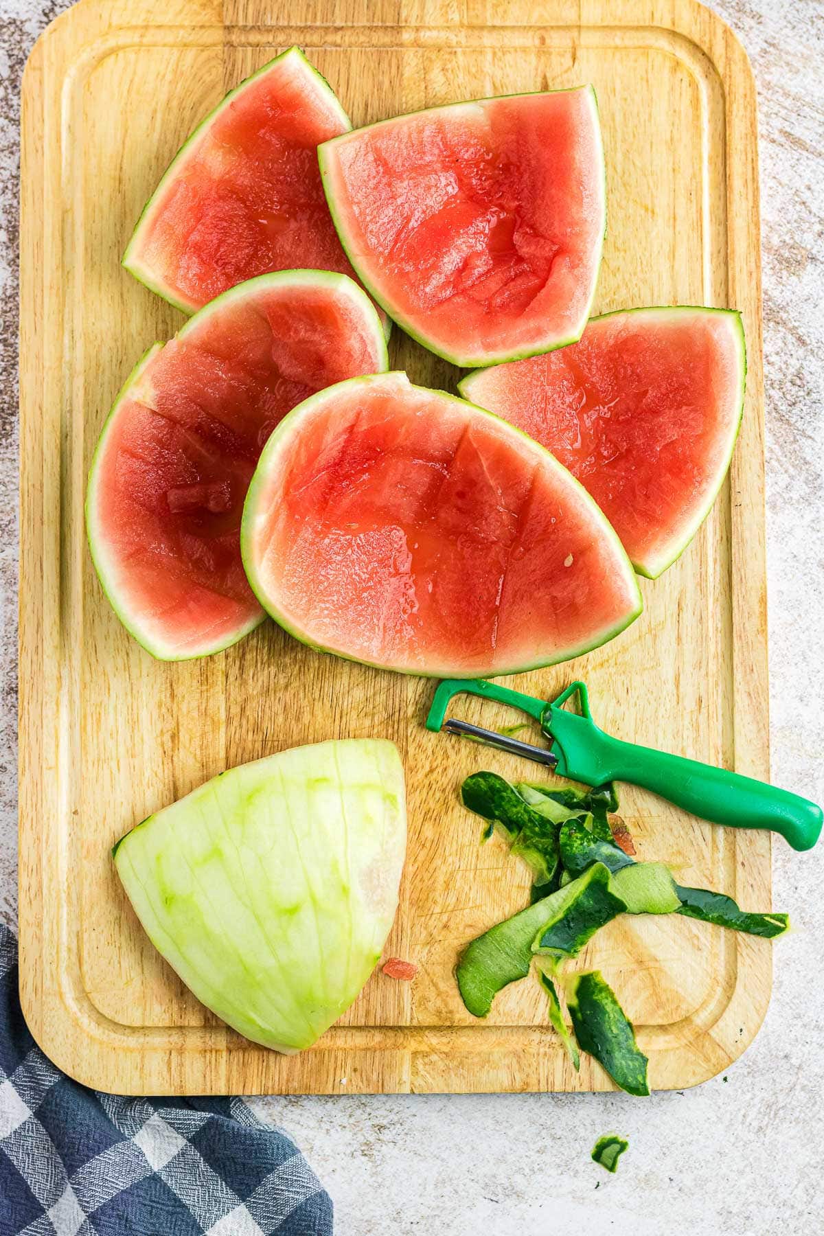 Peeling the skin off of the watermelon.