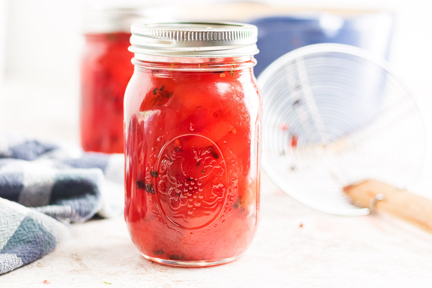 A close-up view of a sealed mason jar of pickled watermelon rind.