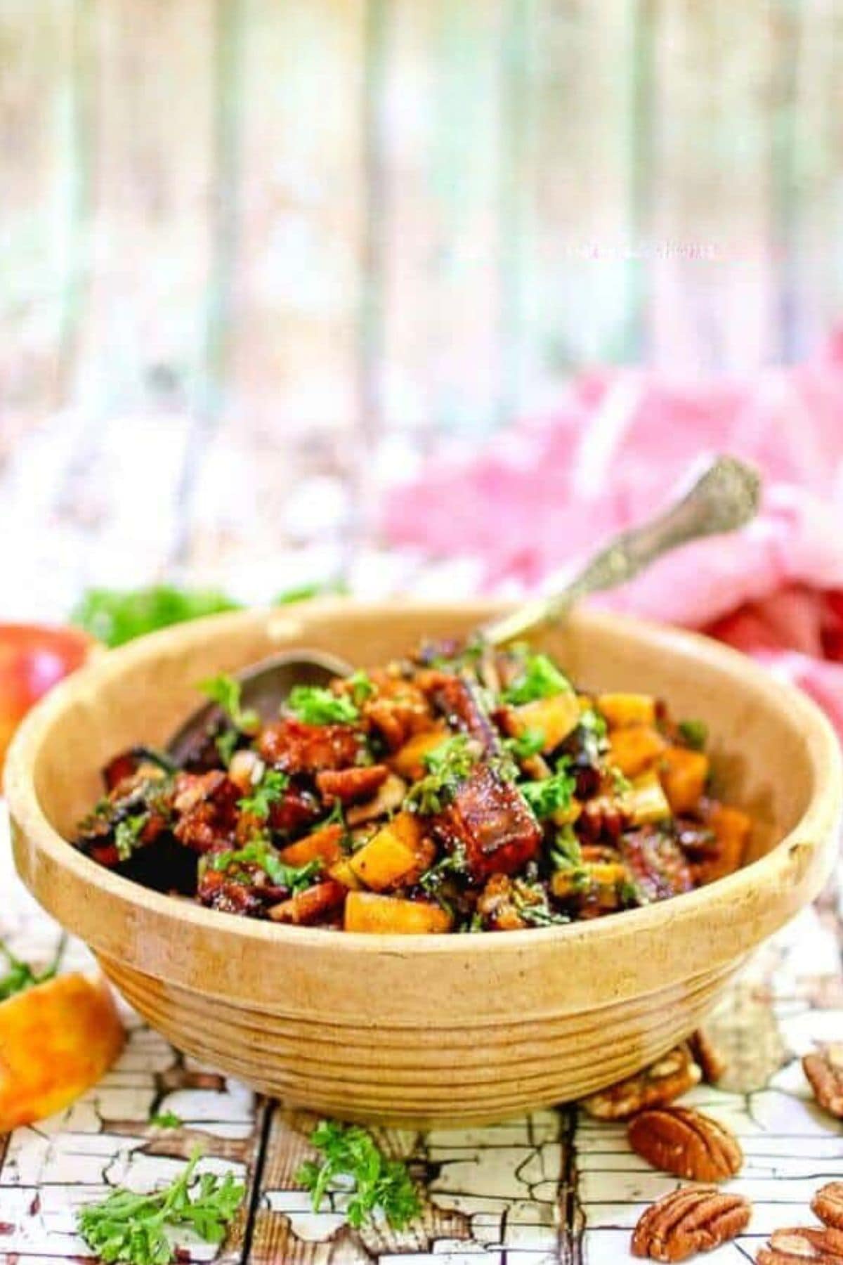 Bowl of roasted sweet potato salad with a serving spoon.