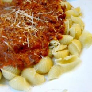 A closeup of shell pasta with a creamy ground beef and tomato sauce.