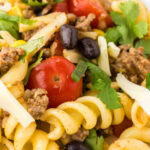 Closeup of pasta salad on a white plate with a title text overlay for Pinterest.