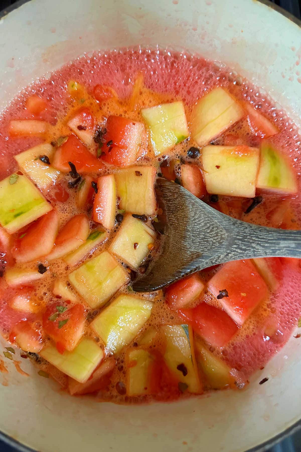 Simmering the watermelon rind in the pickling liquid.