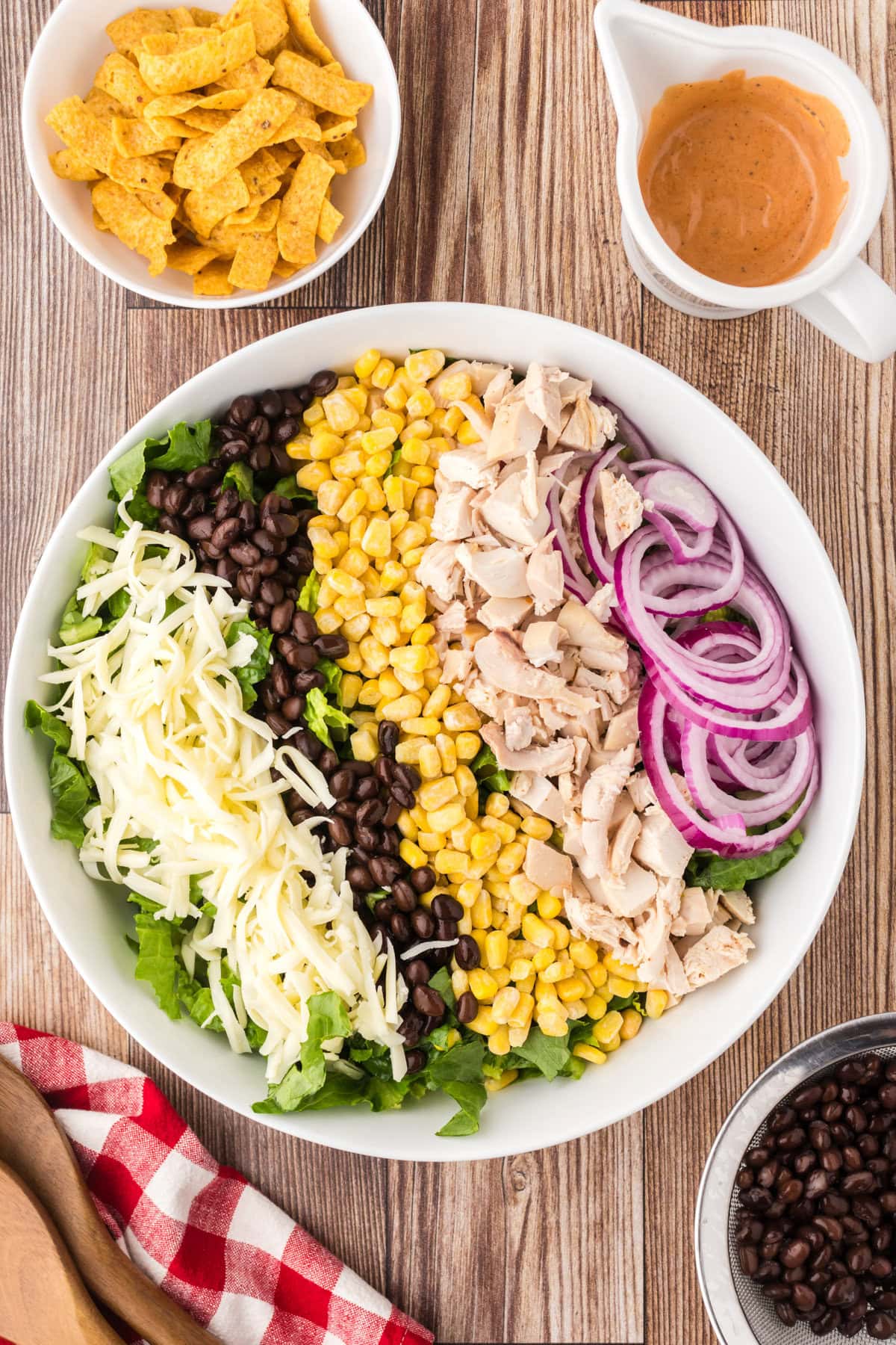 The BBQ chicken salad ingredients layered in a bowl.