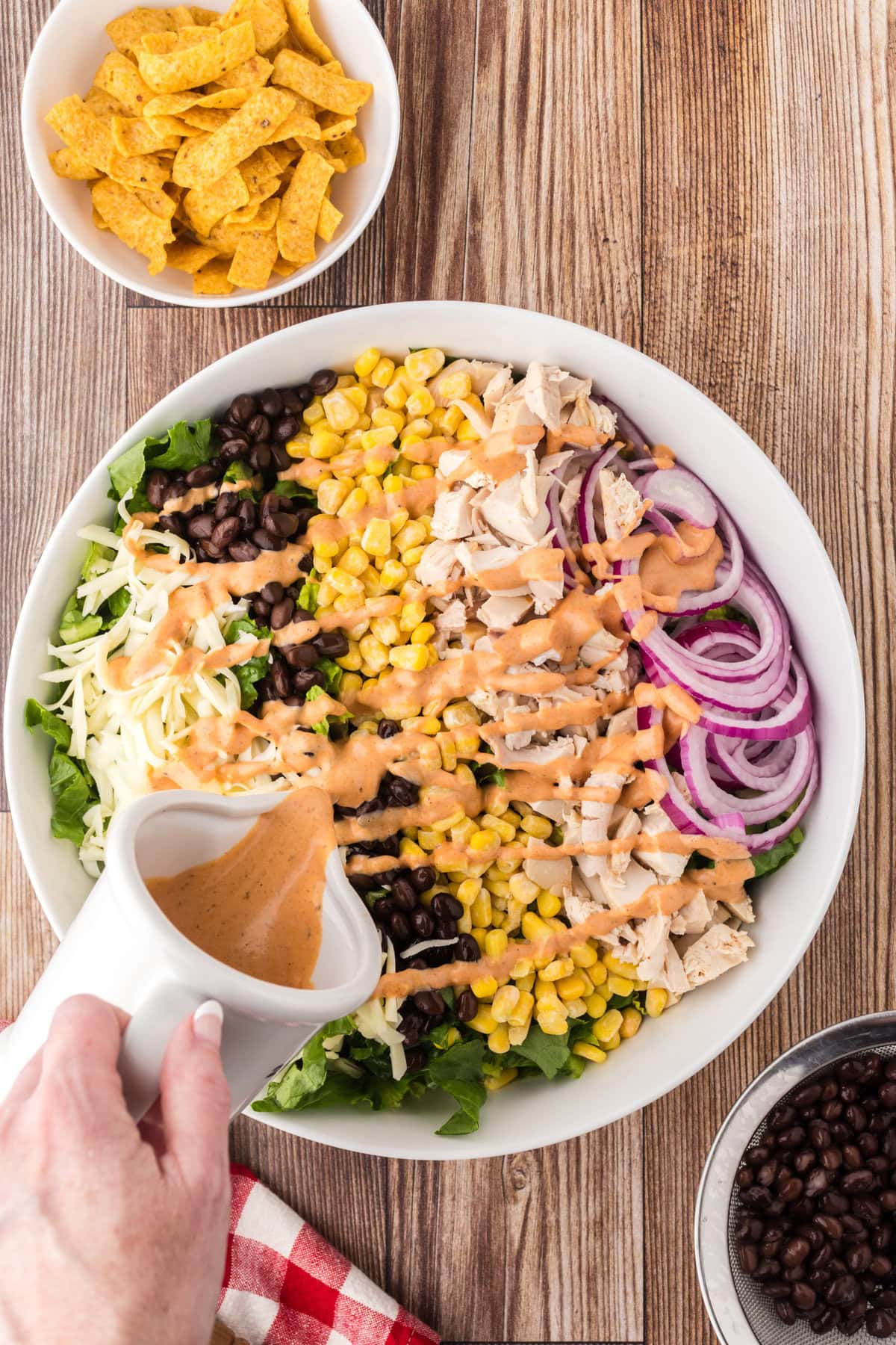 Pouring the dressing over the salad.