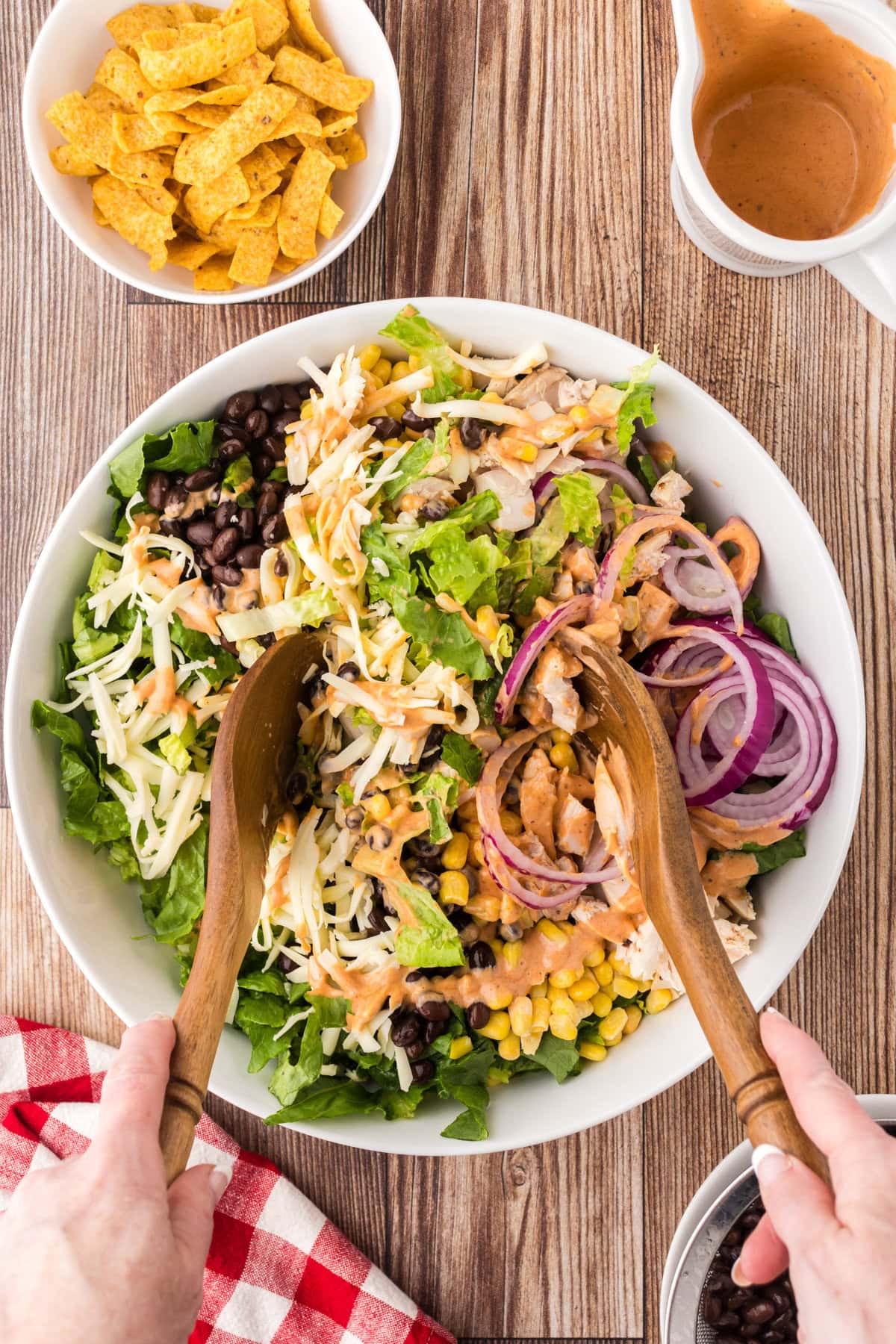 Tossing the salad ingredients with the dressing.