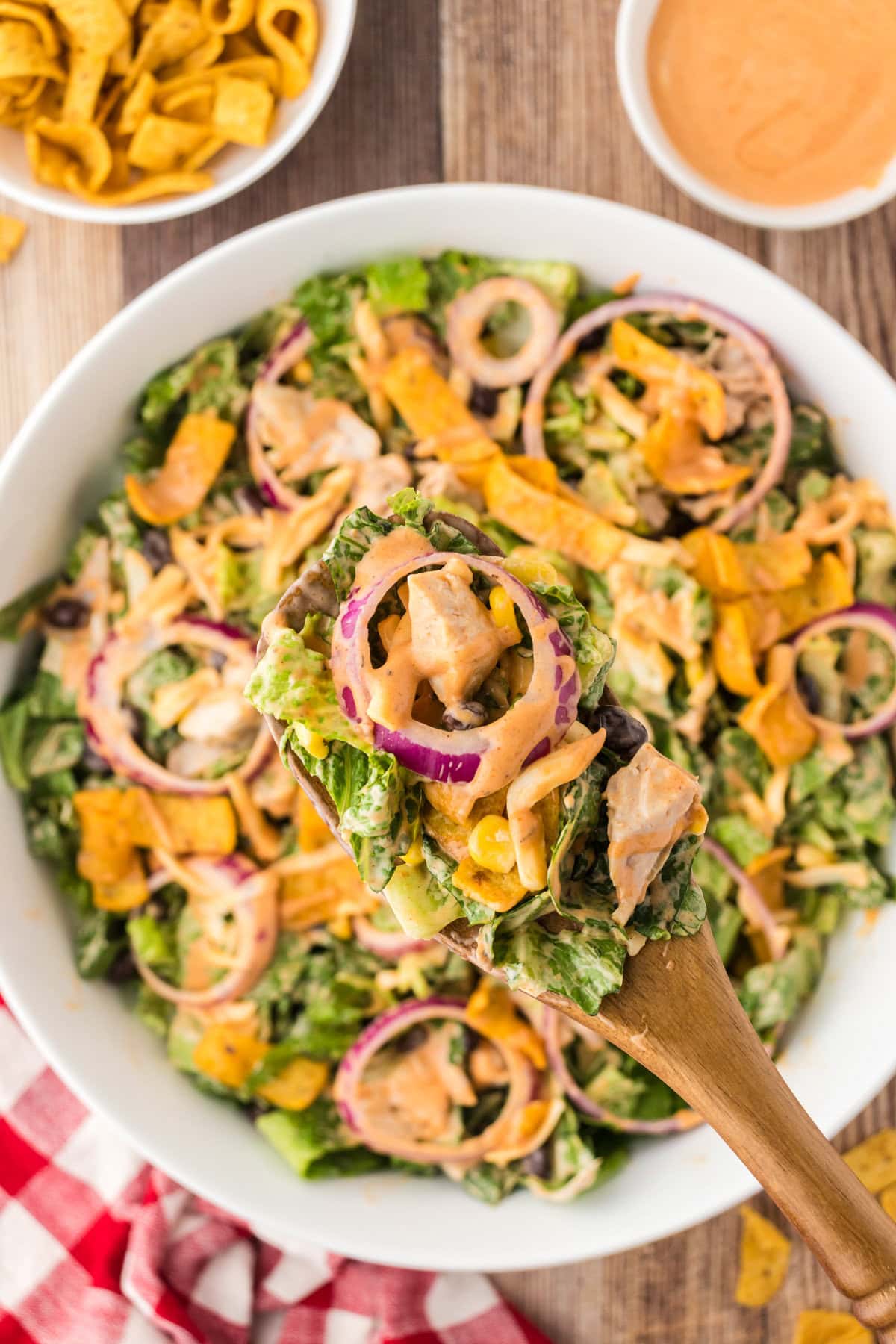 A close-up view of BBQ chicken salad on a serving spoon.