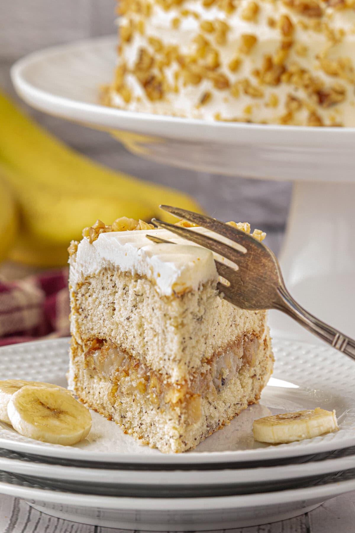 A slice of banana layer cake with walnut filling.