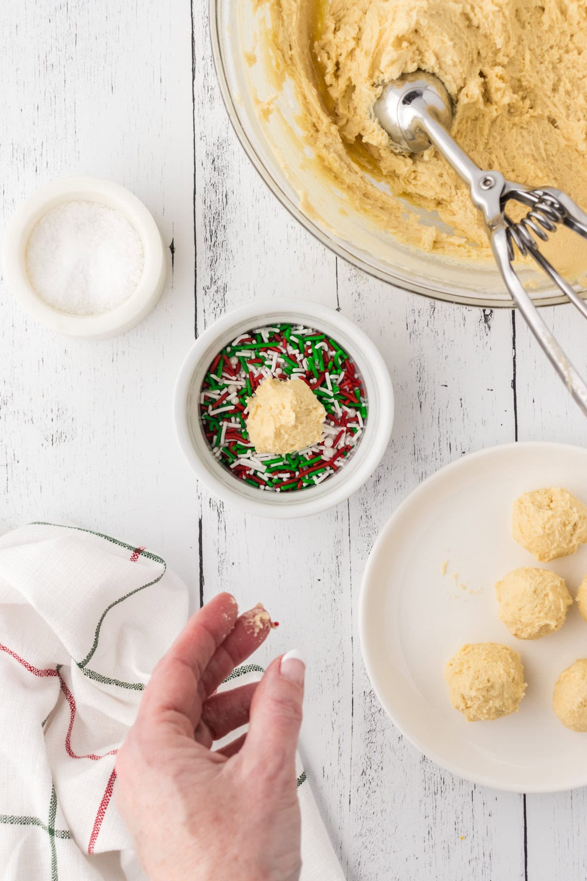 Dipping the dough ball in sprinkes.