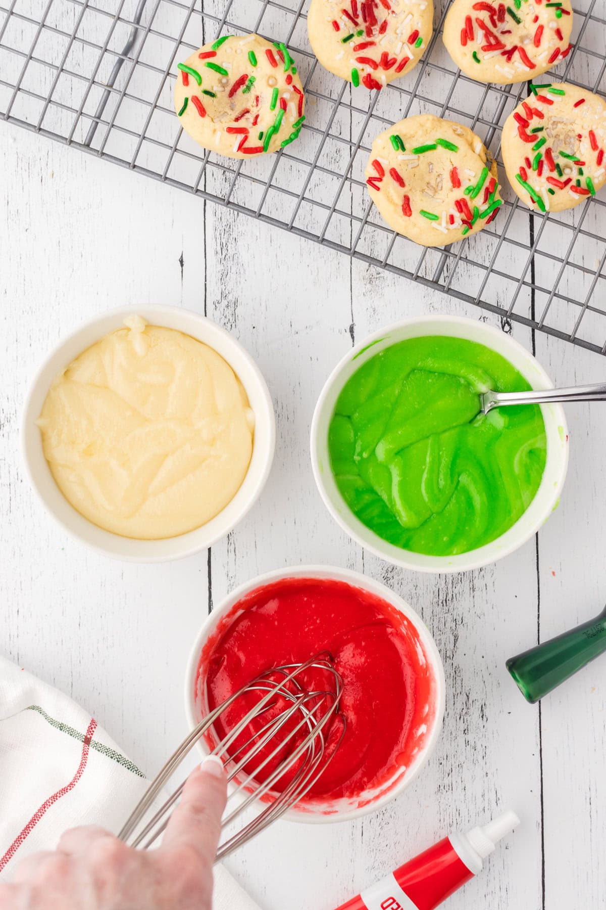 Cookie filling split into three bowls, colored with green and red food coloring.