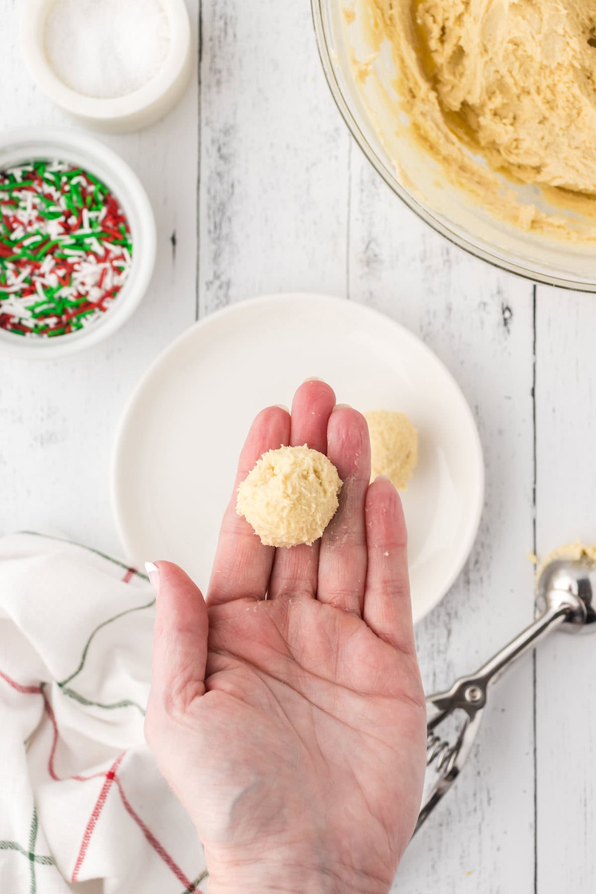 Rolling the thumbprint cookie dough into a dough ball.