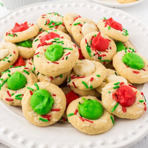 Closeup of Christmas thumbprint cookies with red and green filling.