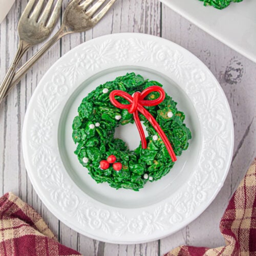 A cornflakes wreath cookie on a white plate.