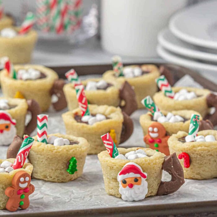 Cute mugs made from cookies and filled with chocolate with marshmallows on top.