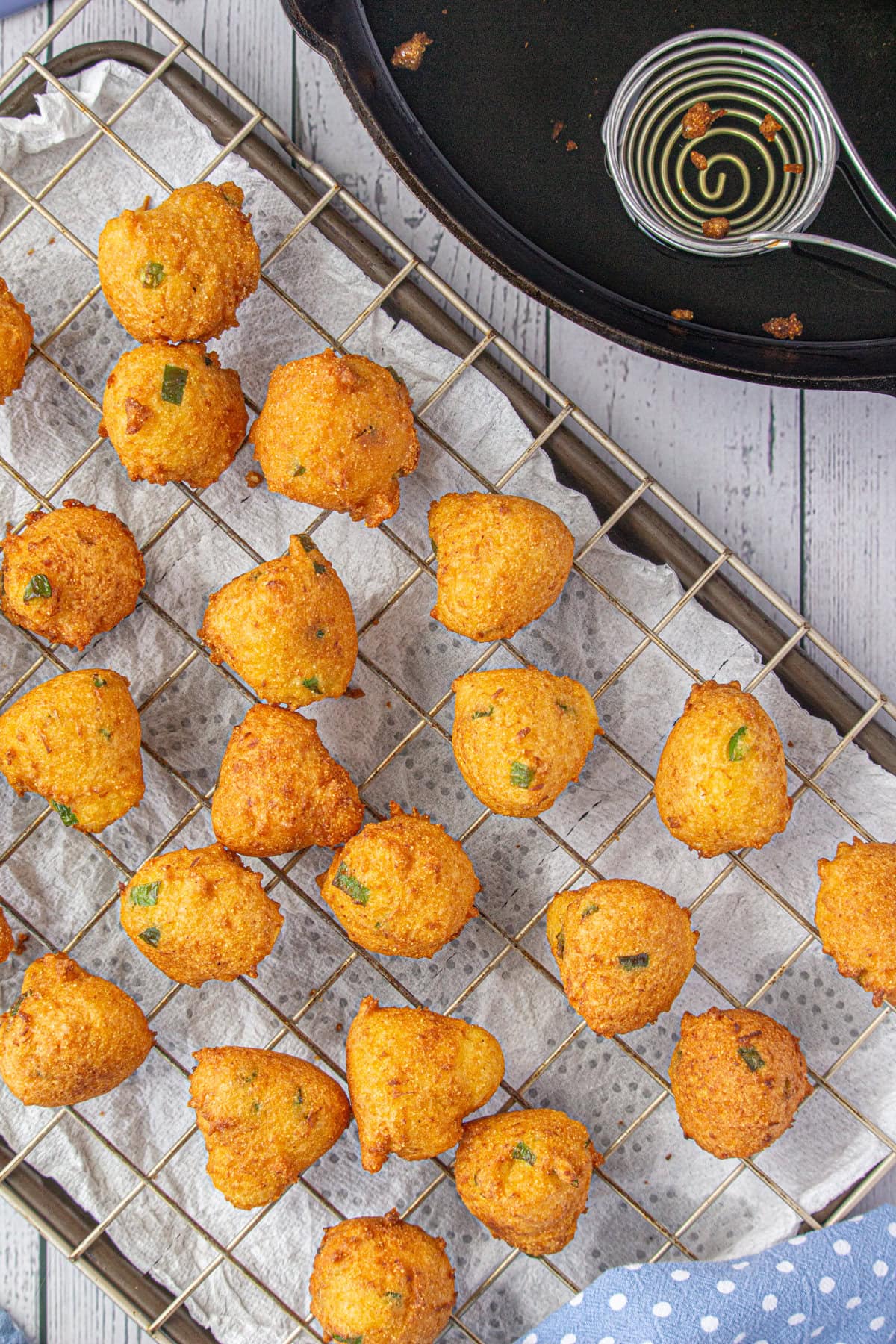 Finished hushpuppies draining on a wire rack.