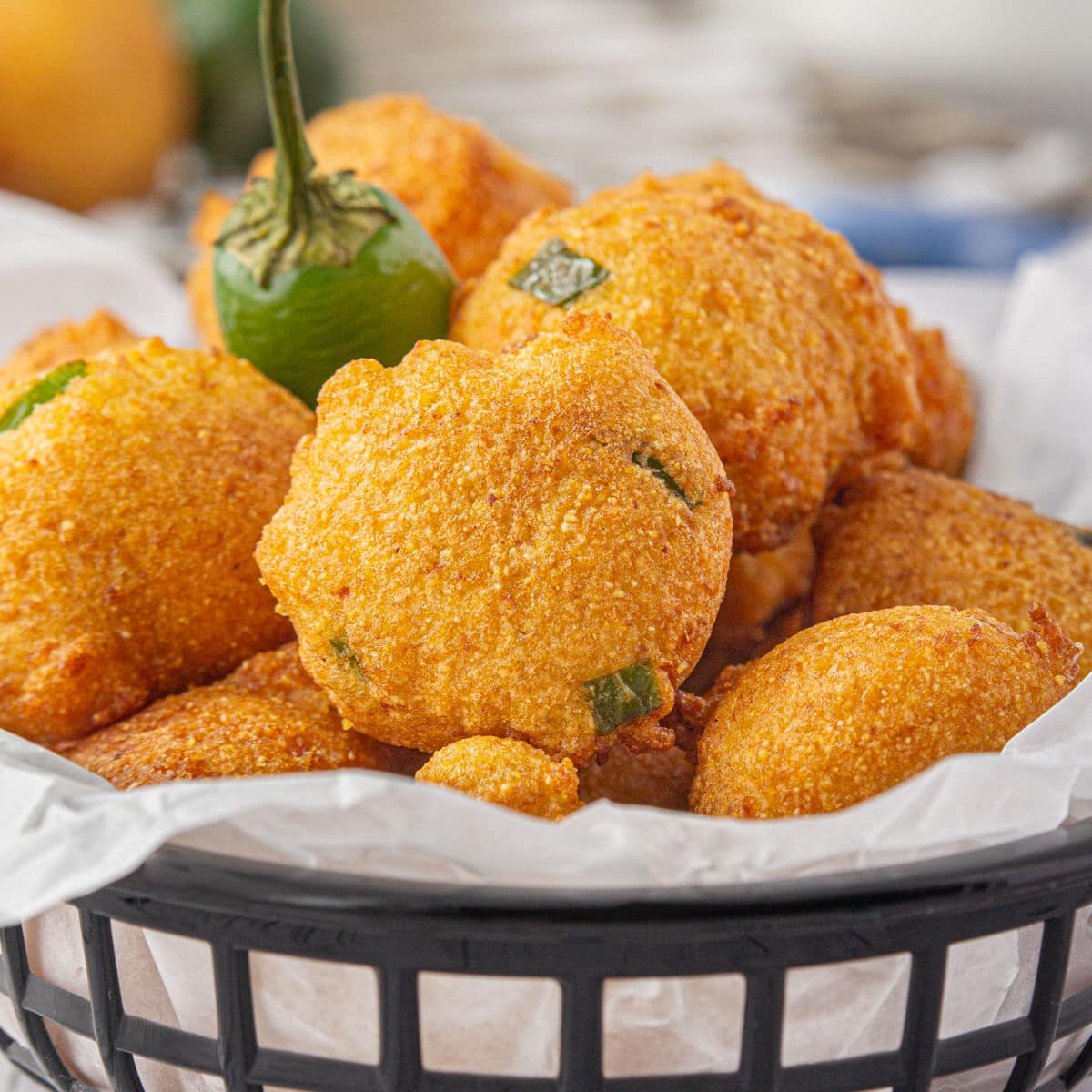 A basket of hushpuppies on a table.