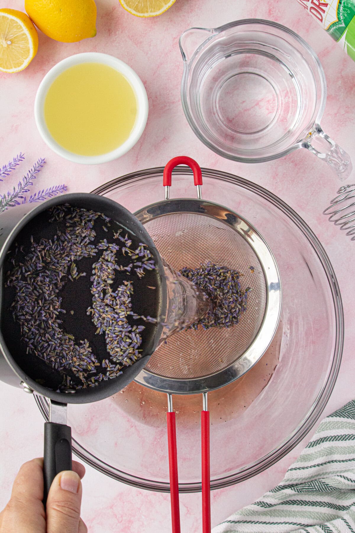 Straining the lavender simple syrup into the punchbowl.