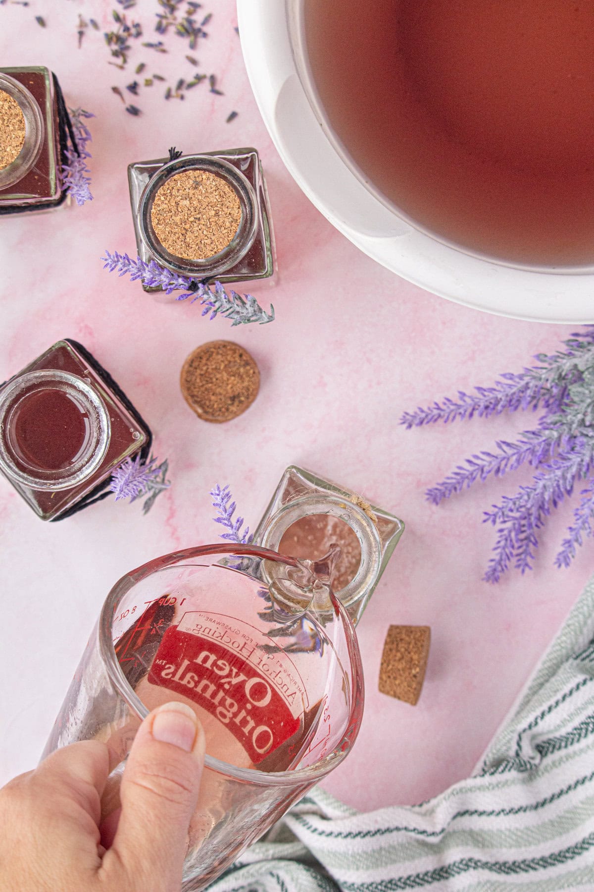 Pouring the lavender simple syrup into a glass jar.