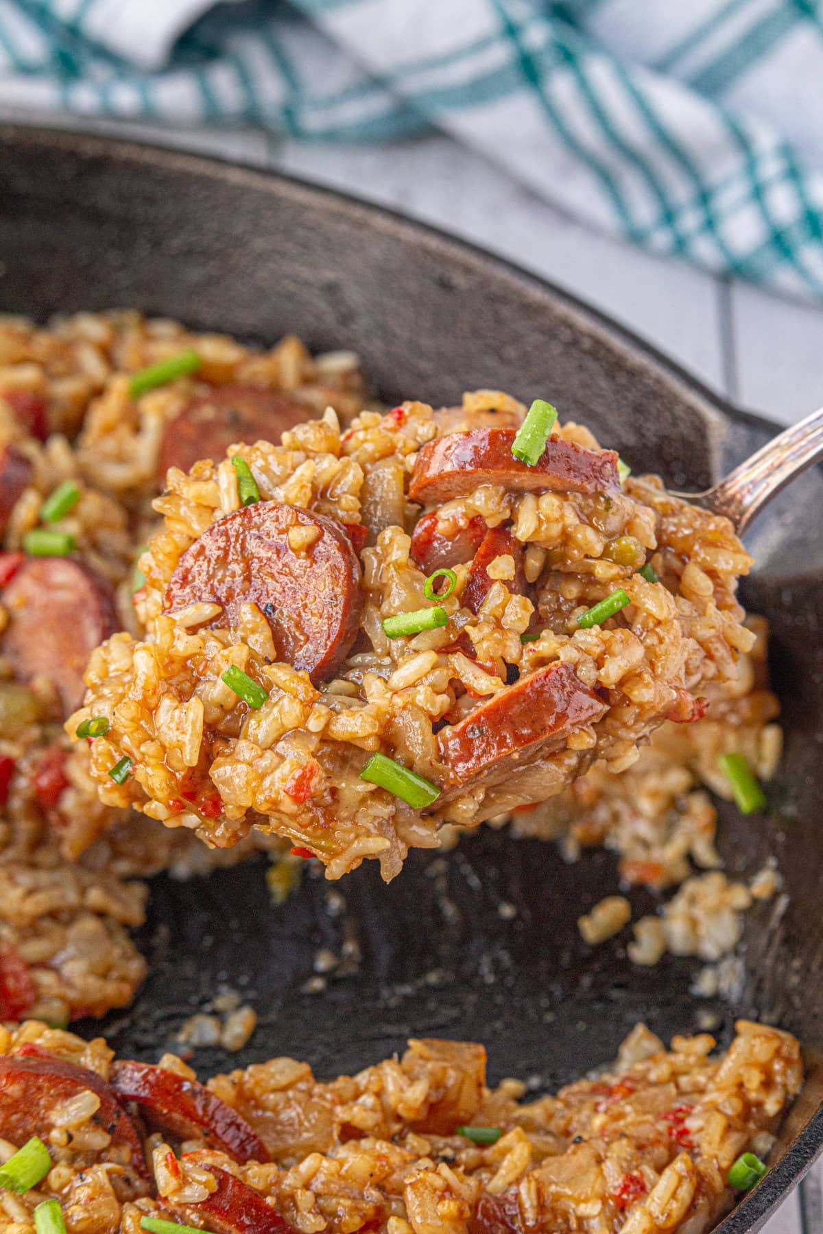 A close-up view of smoked sausage jambalaya on a serving spoon.