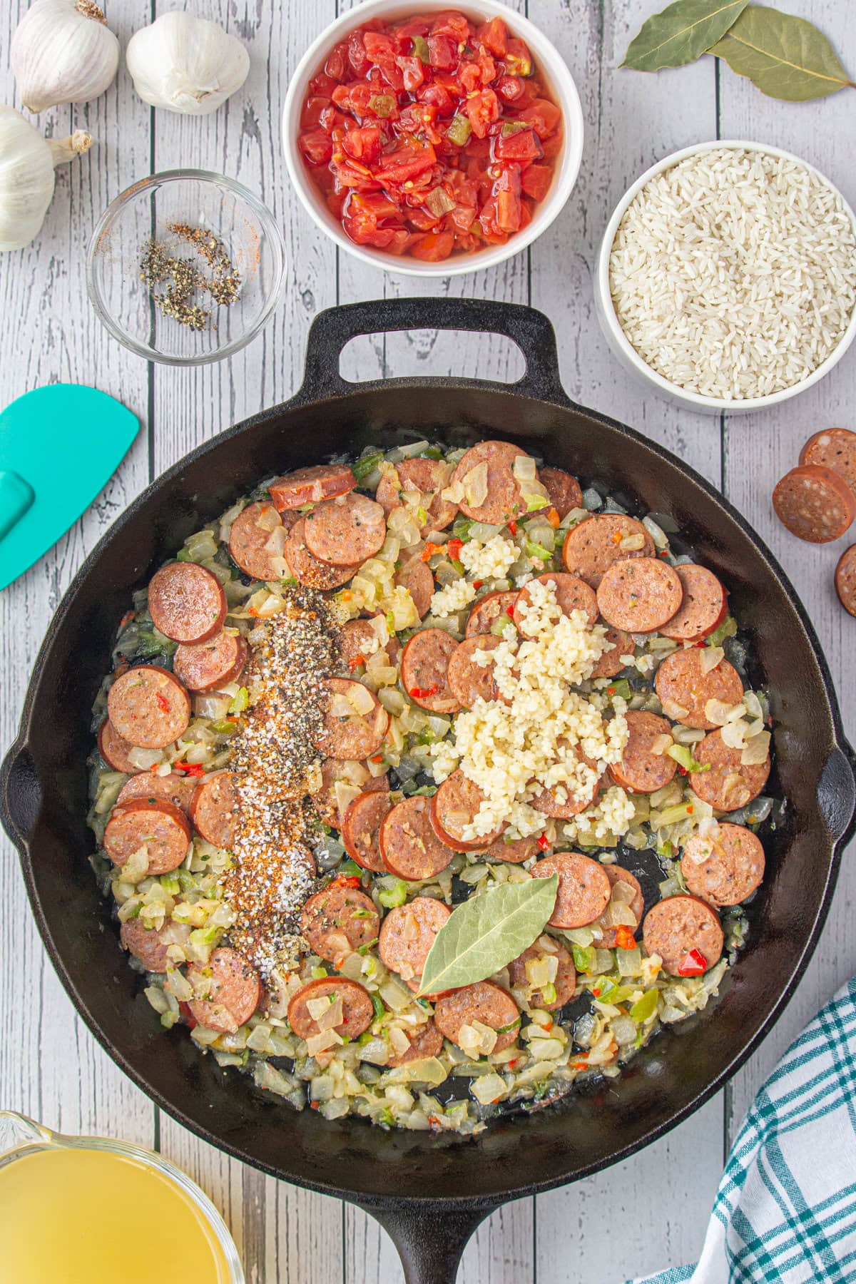 Adding the bay leaf and seasonings to the skillet.