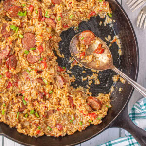 Overhead view of a pan of jambalaya with a serving spoon in it.